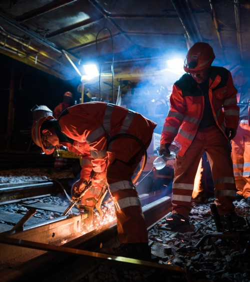 Track workers welding at night