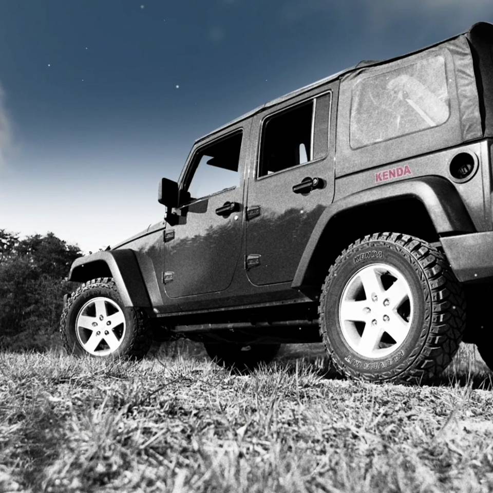 Off-road vehicle with KENDA logo in a meadow