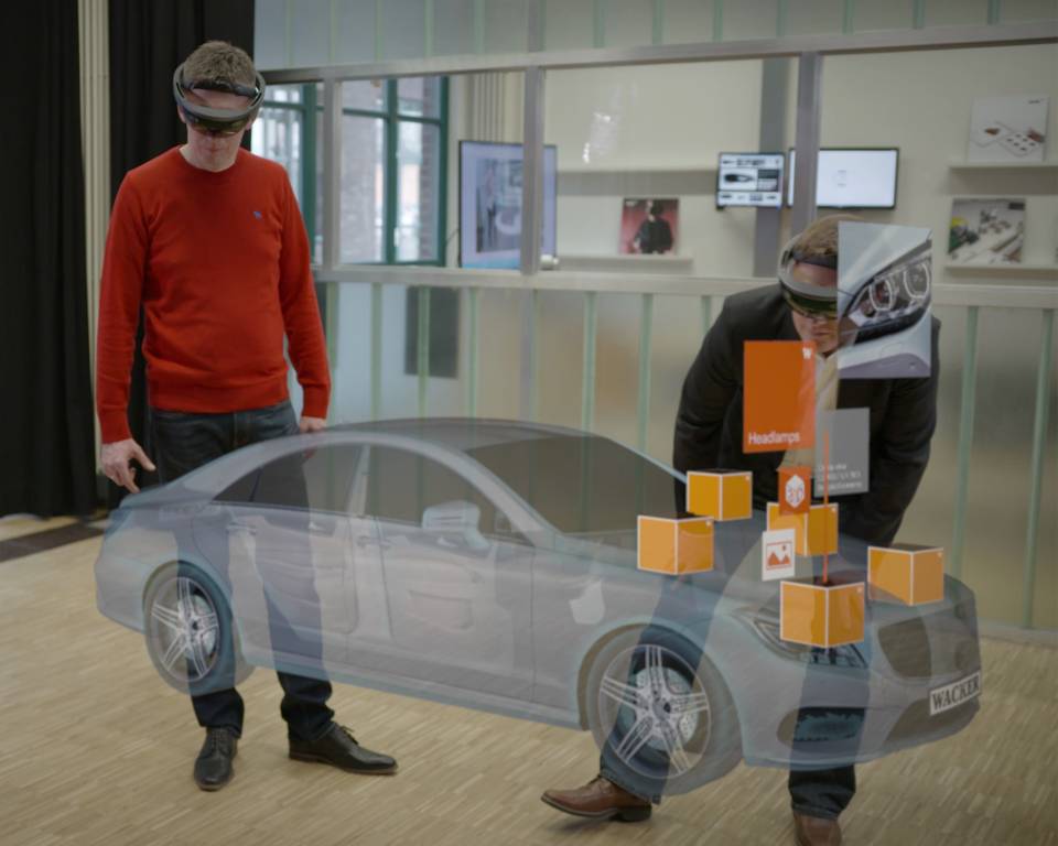 Zwei Personen mit HoloLens und virtuelle Darstellung eines Autos