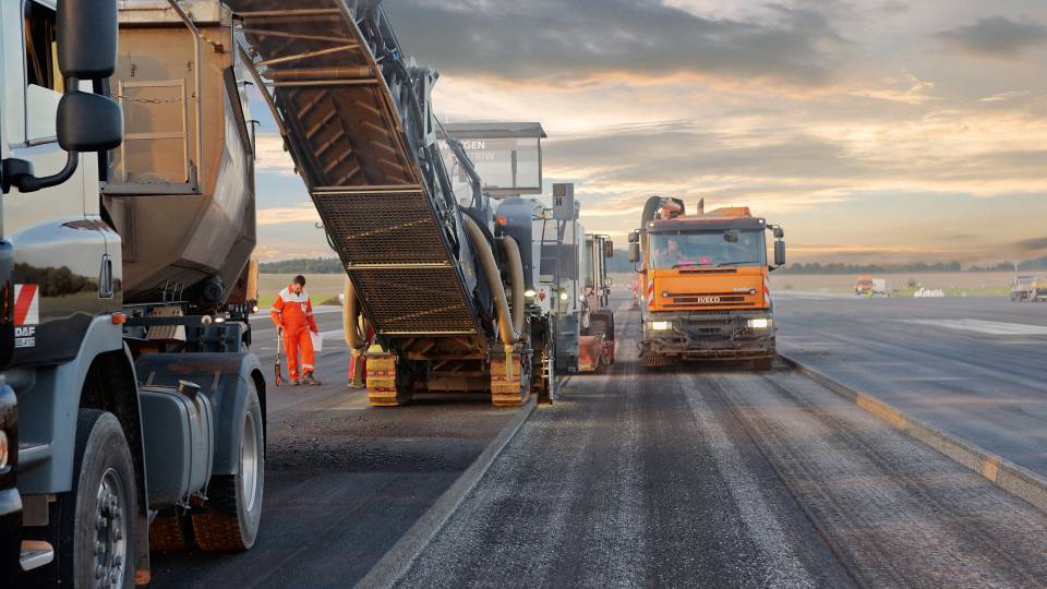 WIRTGEN Kaltfräse Eine WIRTGEN Fräse mit Förderband auf einer Baustelle